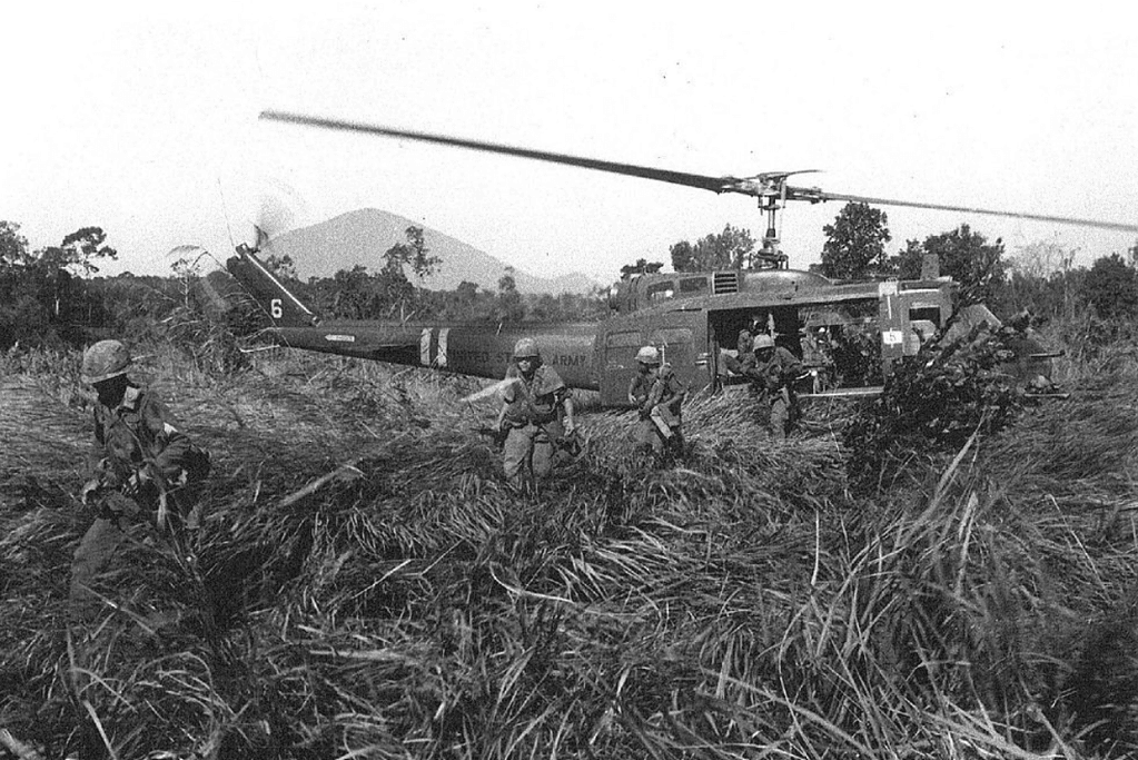 Image of U.S. Army troops disembarking from a helicopter during the Vietnam War