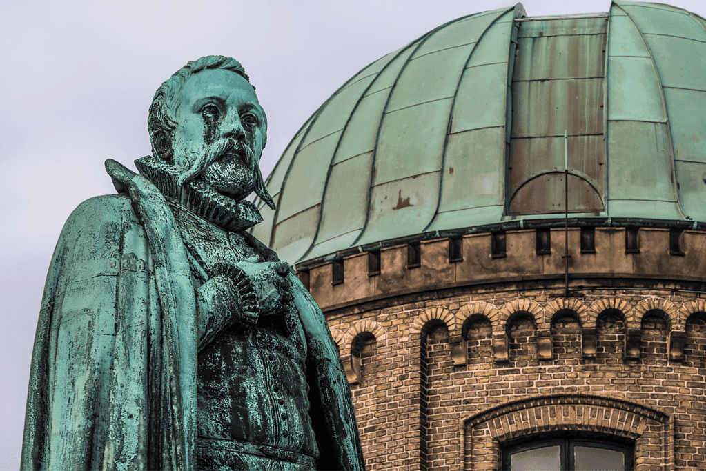 Image of a statue of Tycho Brahe, captured in front of an observatory 