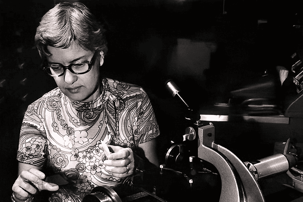 Image of Vera Rubin, a famous astronomer, immersed in the intricate task of analyzing spectra in a research setting.