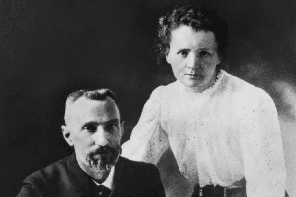 Image of a seated Pierre Curie with Marie Standing for an article covering historic love stories.
