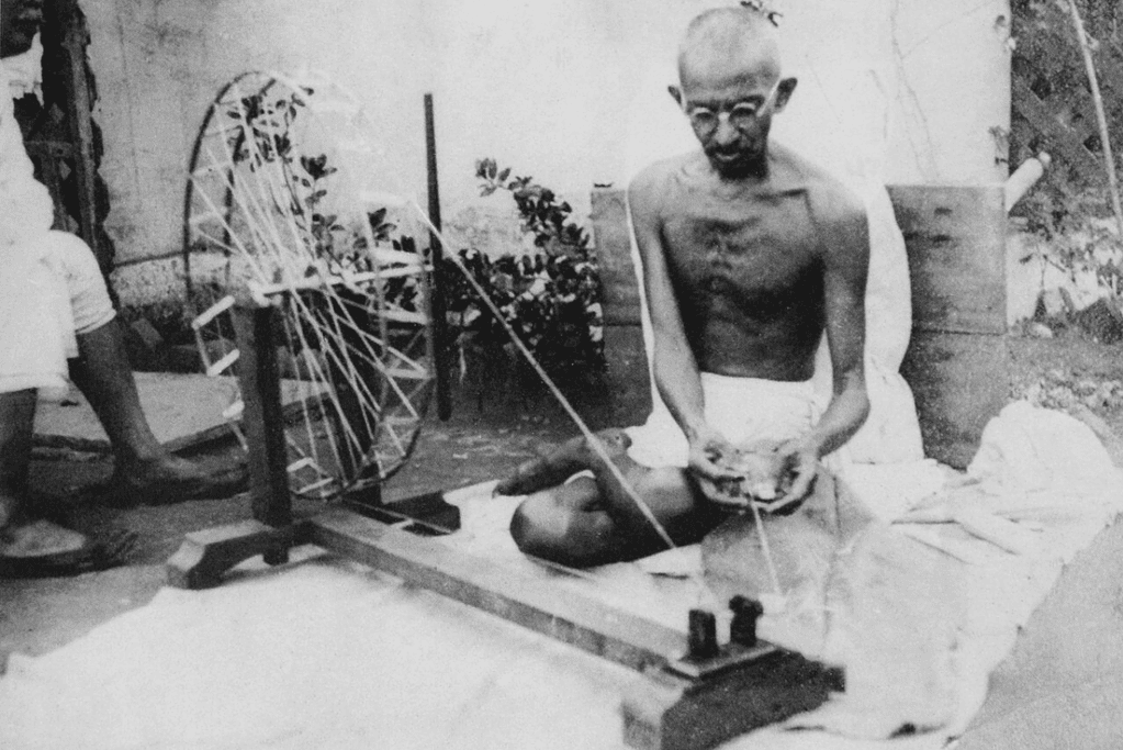 facts-about-mahatma-gandhi-simplicity Image of Gandhi, known for making his own clothing, operates a loom.