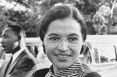 Image of a photo of Rosa Parks with Martin Luther King Jr. in the background for an article covering 10 interesting facts about Rosa Parks.