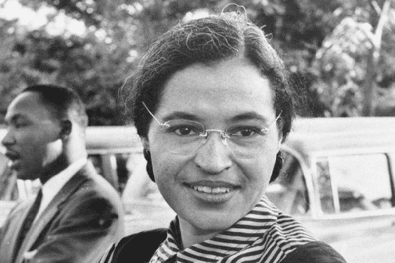 Image of a photo of Rosa Parks with Martin Luther King Jr. in the background for an article covering 10 interesting facts about Rosa Parks.