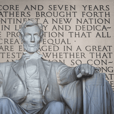 Image of the statue of Abraham Lincoln at the Lincoln Memorial in Washington, D.C. with the Gettysburg Address imprinted in the wall behind Lincoln, for an article covering 10 interesting facts about the Gettysburg Address.