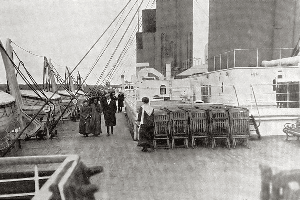 Image of passengers leisurely walking on the upper decks of the RMS Titanic, experiencing the grandeur of the ship's design and amenities.