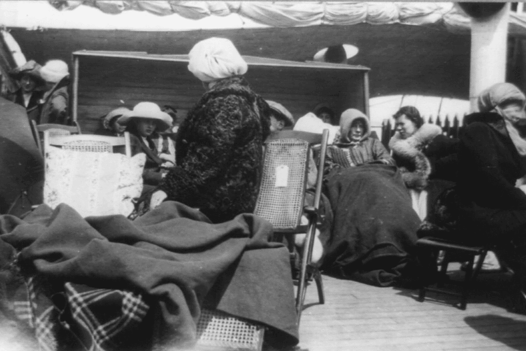 Image of a photo of survivors from the Titanic tragedy, huddled on the Carpathia's deck with blankets for warmth and comfort after their dramatic rescue.