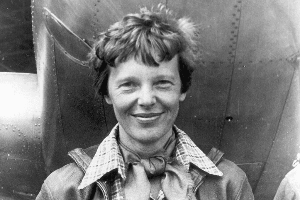 Image of the greatest female aviation pioneer posing in front of a period aircraft.