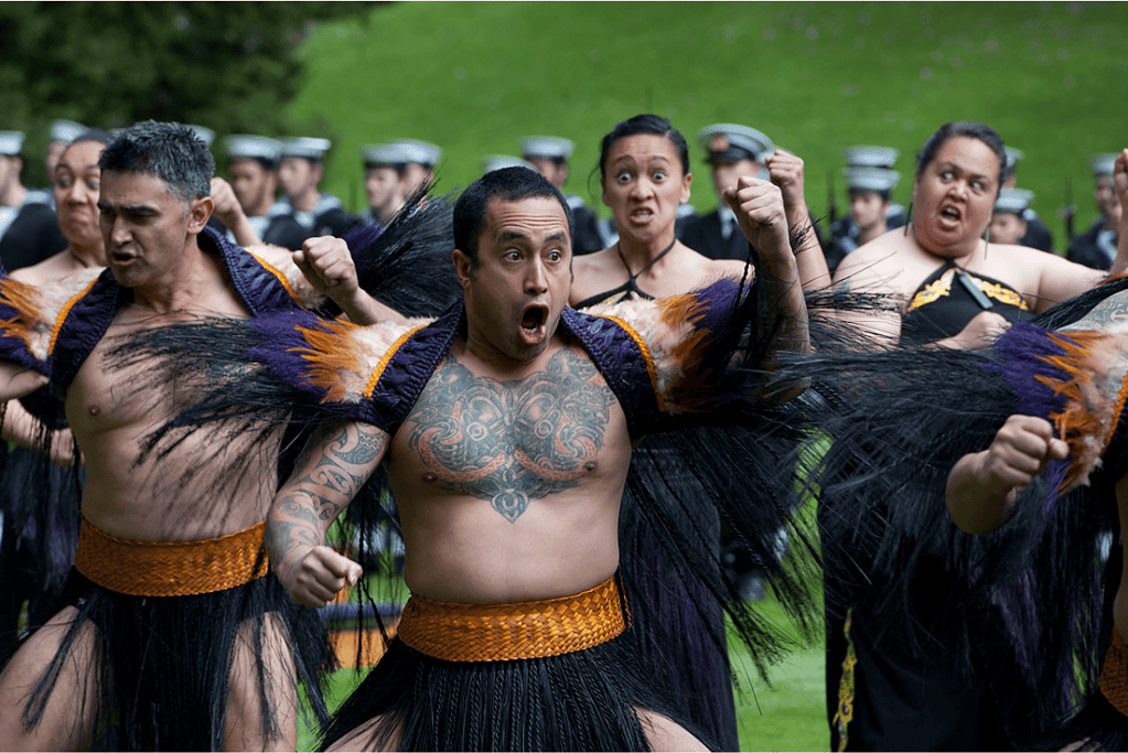 Image of Māori men and women performing a traditional haka ceremonial dance for a blog post covering Māori history.