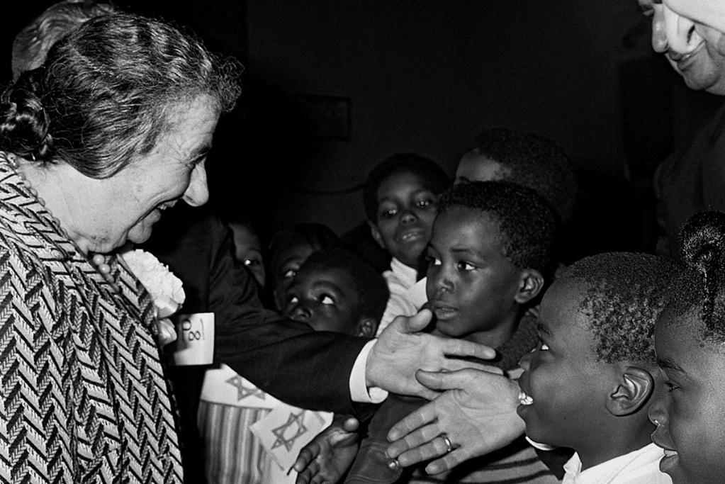 facts-about-golda-meir-nickname Image of Israeli Prime Minister Golda Meir being greeted by a group of children.