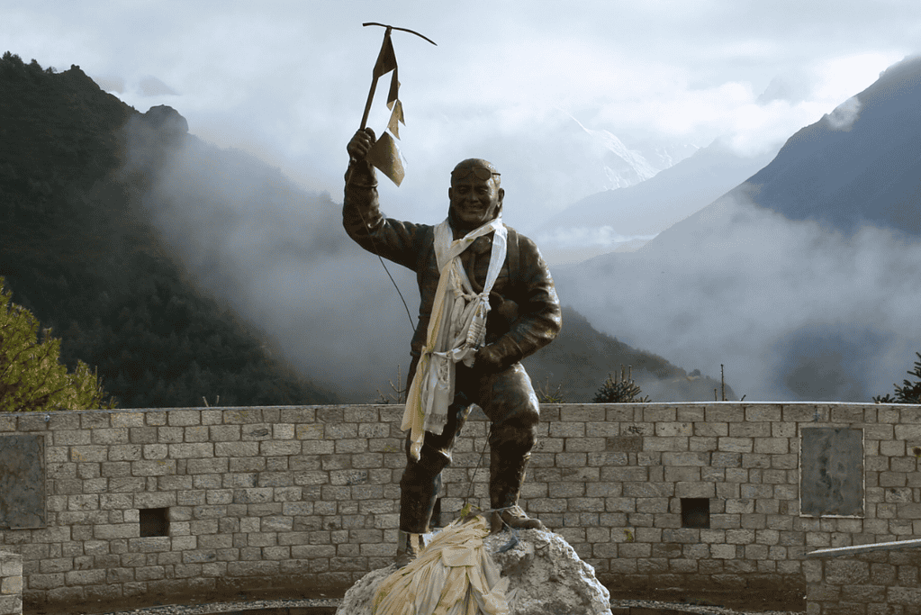 famous-mountain-climbers-tenzing-norgay Image of a statue honoring Tenzing Norgay, mountain climber and sherpa with Mount Everest in the background.
